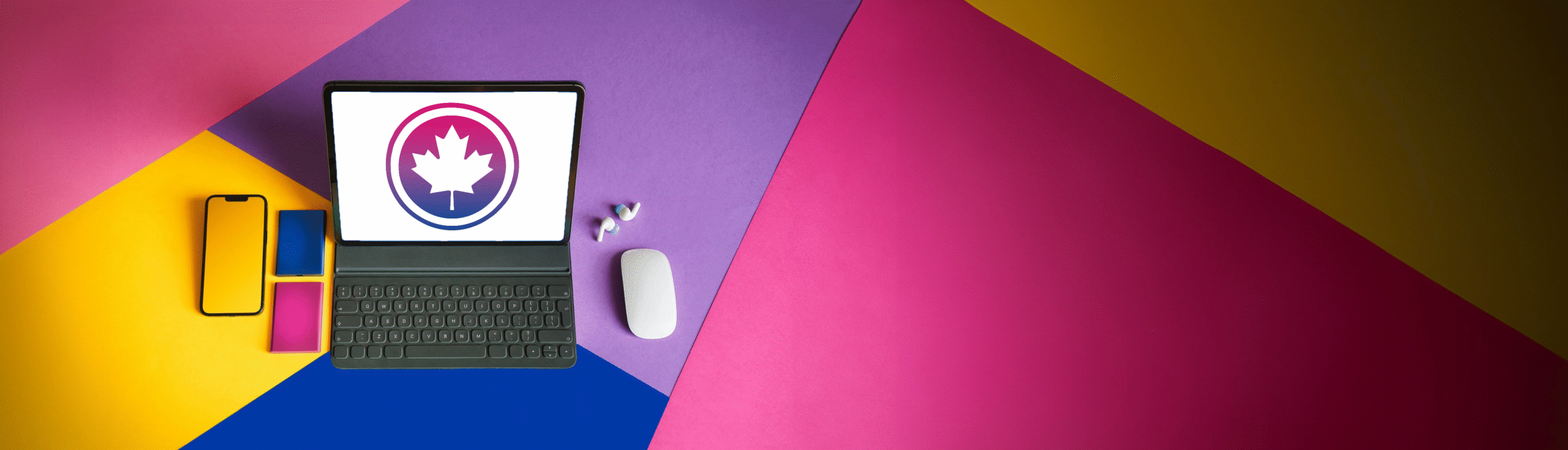 A laptop with the Bi+ Canada logo on the screen sits on a pink, purple, blue, and yellow surface. 