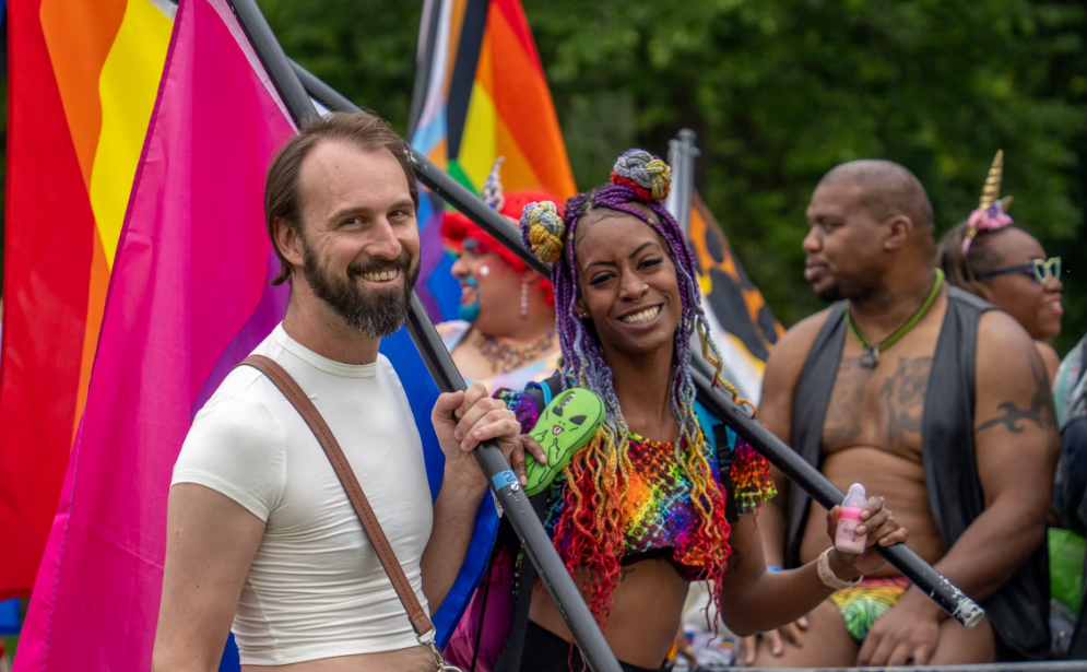 A group of people holding flags at a pride parade.